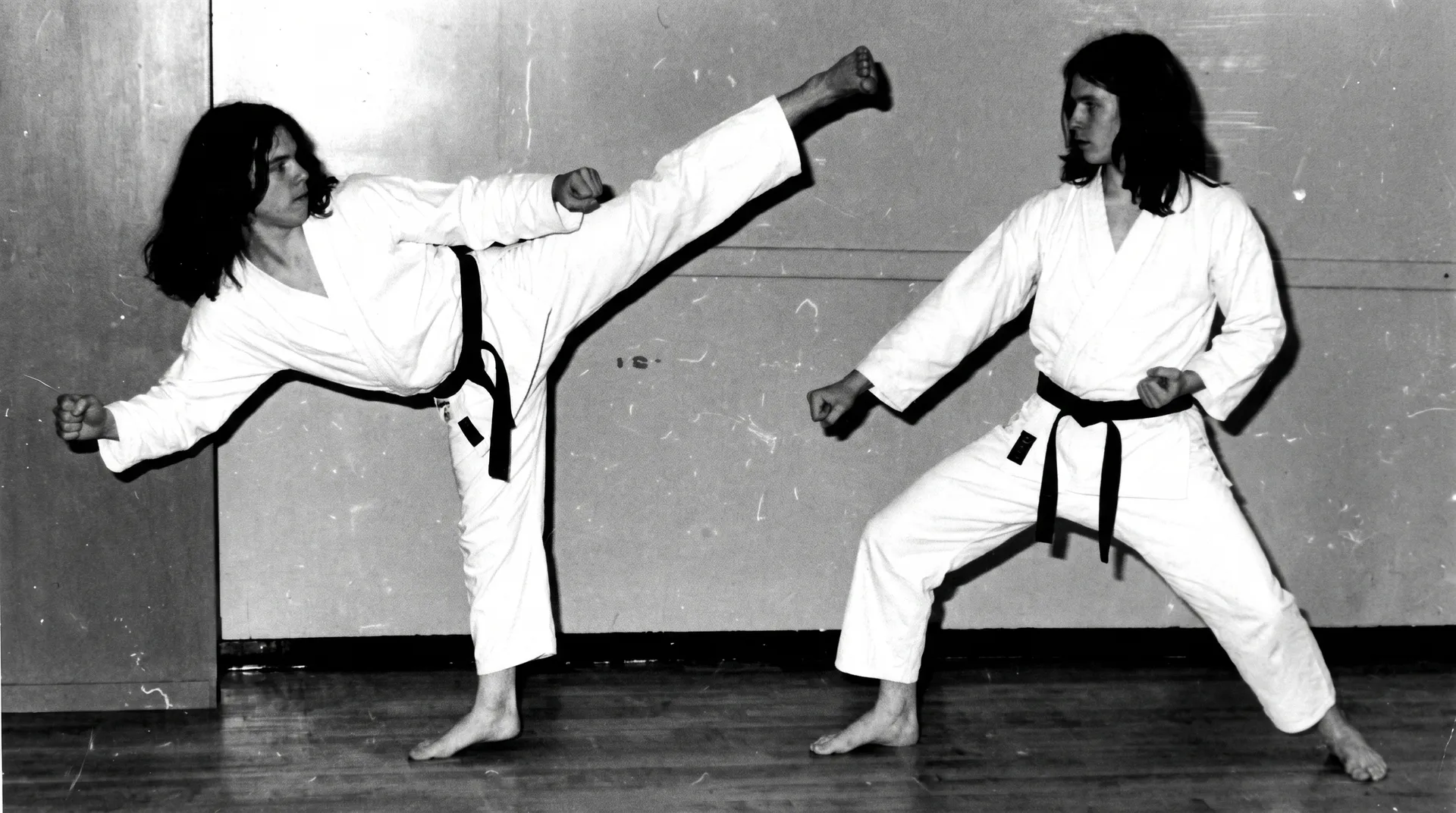 Black and white archive photo of two members sparring with a high kick