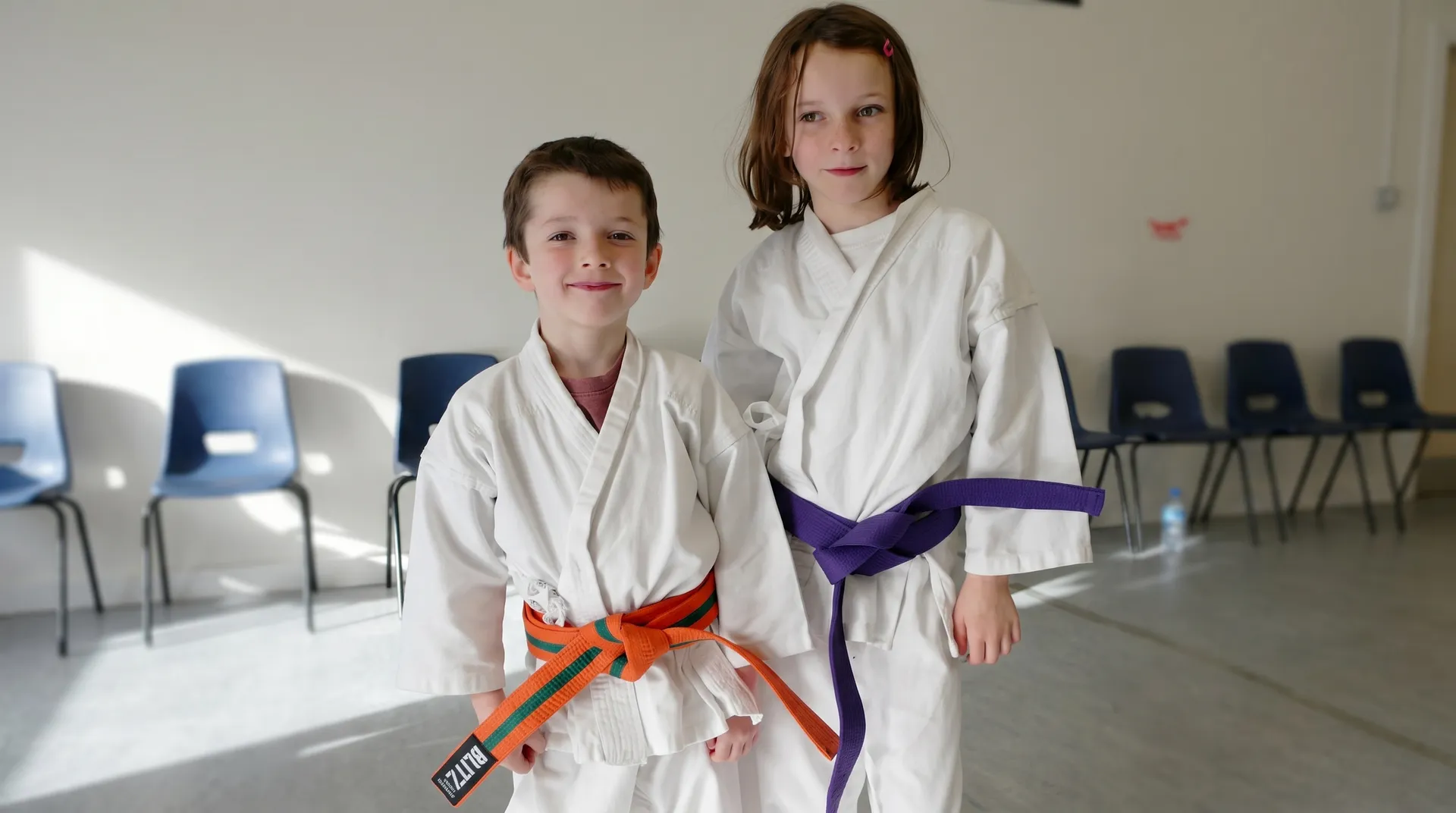 Two young members in white gis with orange and purple belts