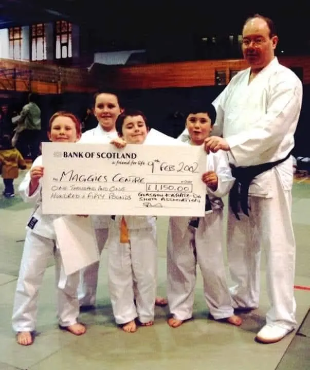 Junior members holding a cheque for £1,150 made out to Maggie's Centre, February 2002